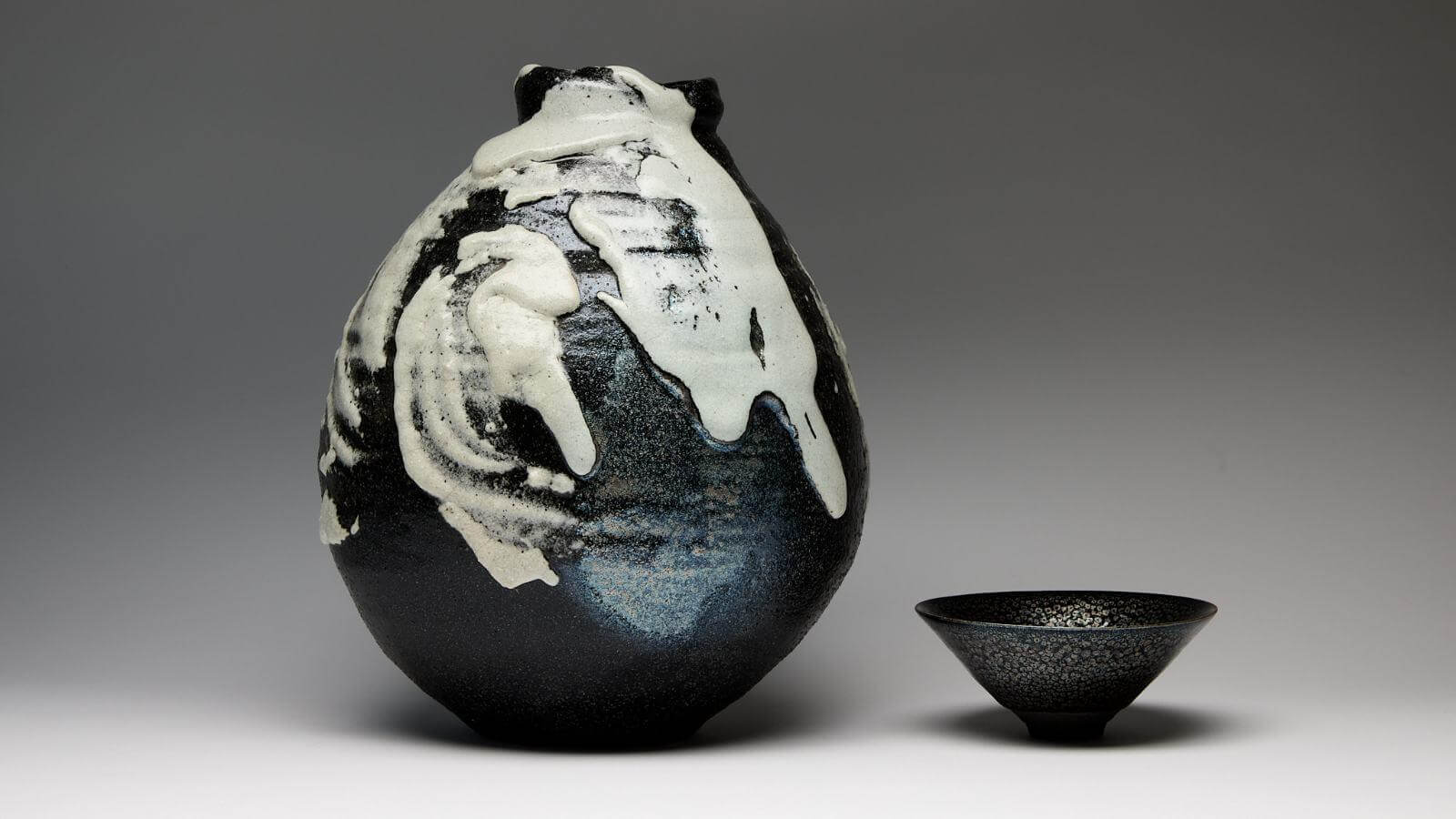 Shimizu Uichi, (left to right): ‘Iron-Glazed White-Flow Ash-Glazed jar’, 1993; ‘Iron-Glazed Oil-Spot Tenmoku Tea Bowl’, 1977 COURTESY: The Artist & Carpenters Workshop Gallery / PHOTOGRAPH: Callum Su